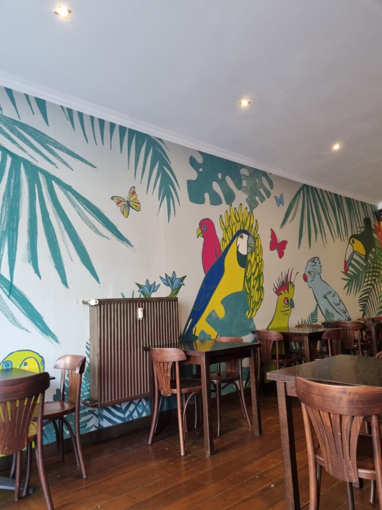 walls with painted parrots in cosy vegan restaurant in Mechelen
